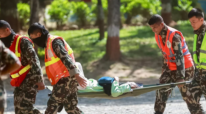 Nepali Army personnel carry an evacuated person on a stretcher during rescue operations following severe flooding in Nepal.