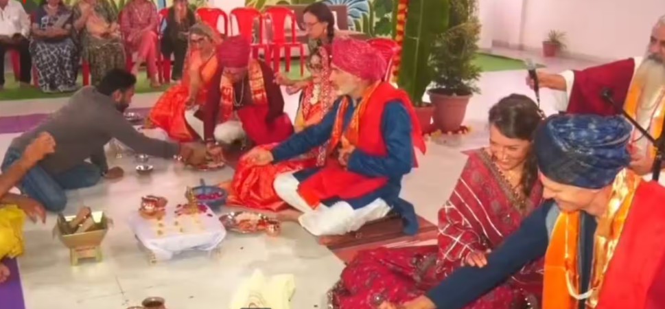 Foreign couples participate in a traditional Vedic wedding ceremony in Ujjain, India, wearing traditional Indian wedding attire.